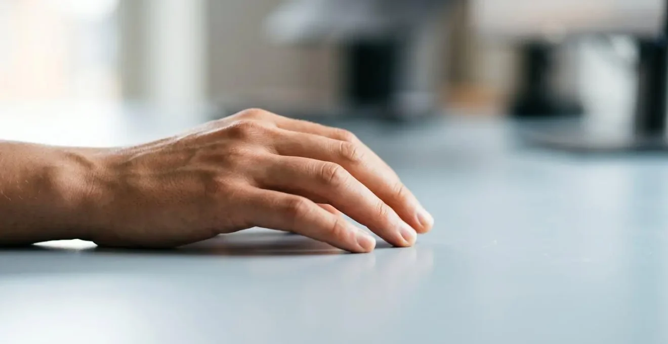Main en position naturelle sur espace de travail ergonomique, symbolisant la prévention des troubles musculosquelettiques au bureau